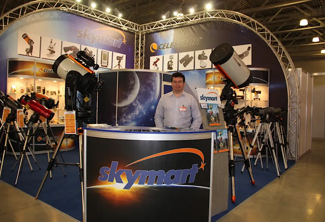 Станислав Аксенов на выставочном стенде Skymart с телескопами Celestron
