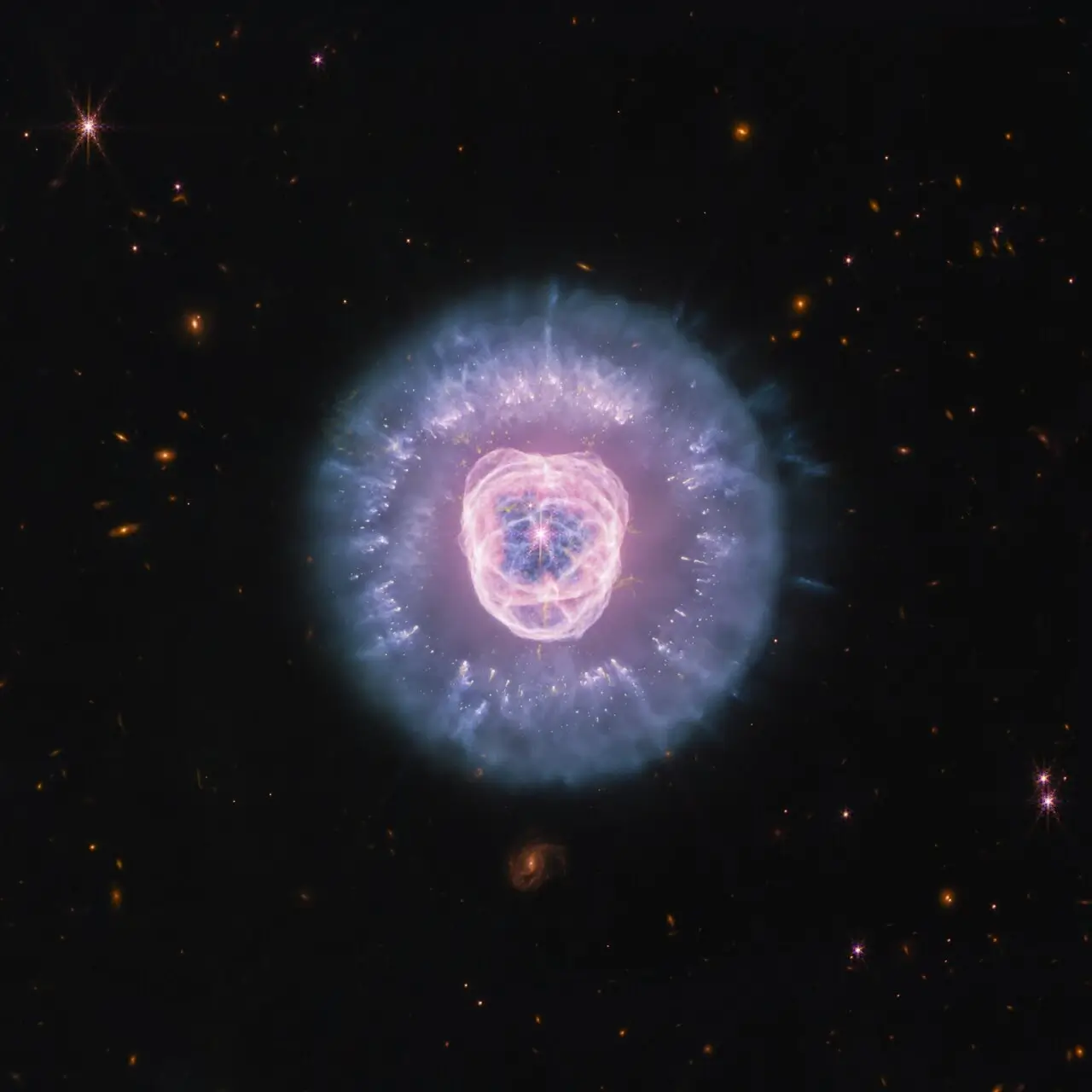 Туманность Эскимос NGC 2392 на снимке телескопа Уэбба: белый карлик в центре и пылевая грива